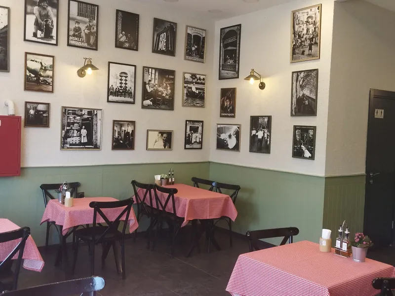 Povera Pizzeria’nın içi: kareli masa örtüleri ve duvarda siyah beyaz fotoğraflar
